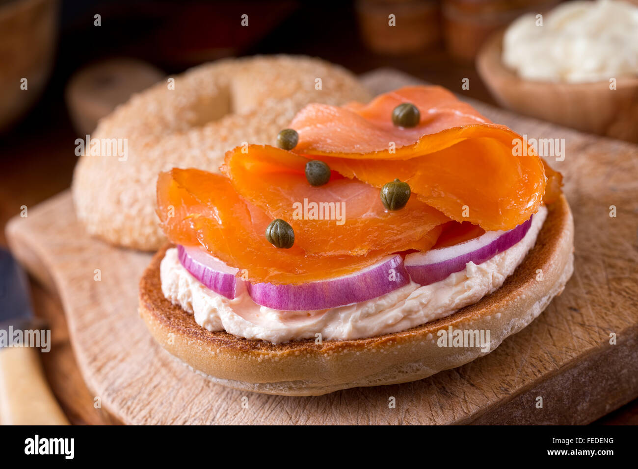 A delicious homemade toasted sesame seed bagel with smoked salmon, whipped cream cheese, red onion, and capers. Stock Photo