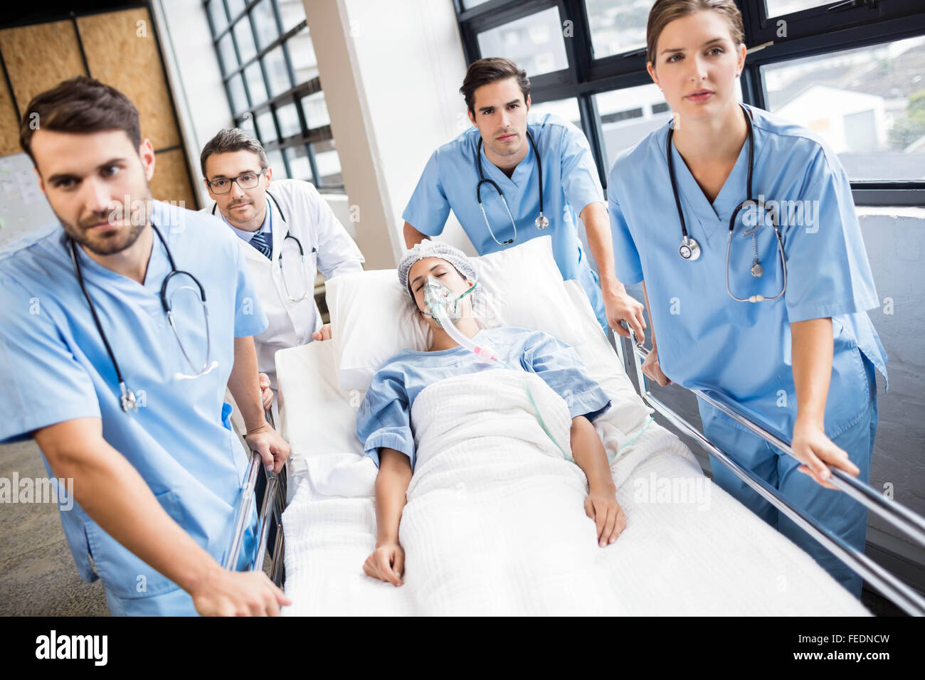 Medical team pushing patient on trolley Stock Photo Alamy