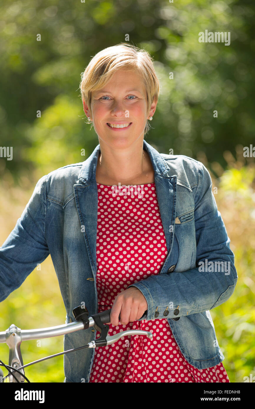 Woman with her bicycle in nature Stock Photo