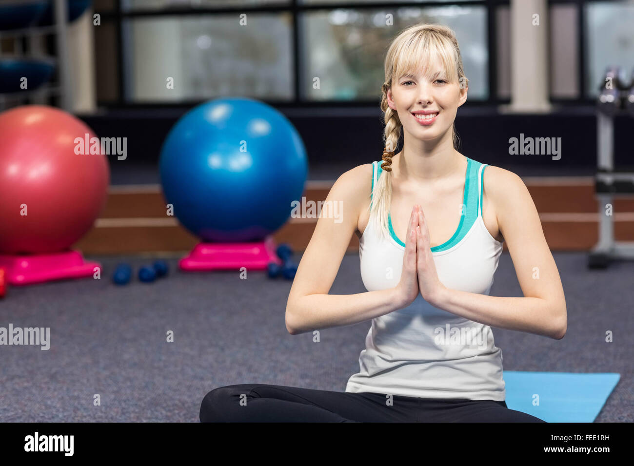 Smiling woman doing yoga exercise Stock Photo - Alamy