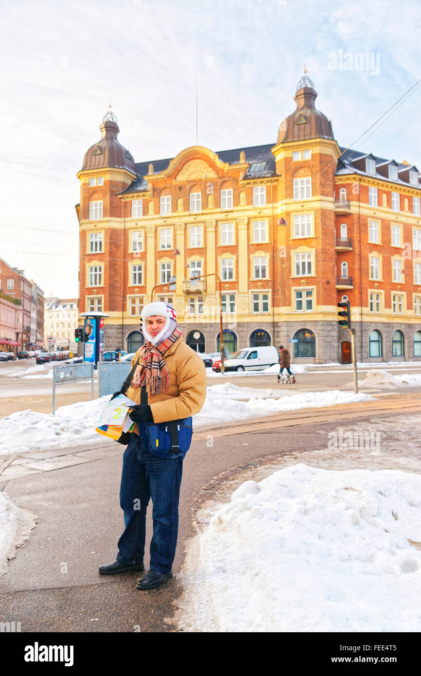 Man holding map in Kopenhagen city center in winter. Kopenhagen is the capital and most populated city of Denmark. It was found Stock Photo