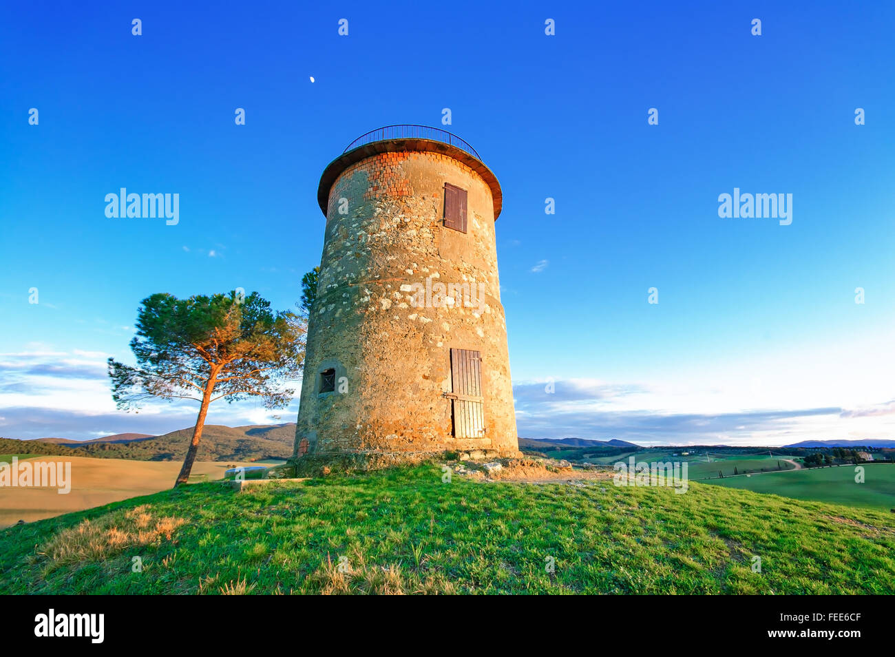 Tuscany, Maremma typical countryside sunset twilight landscape with hills, tree and rural tower. Stock Photo