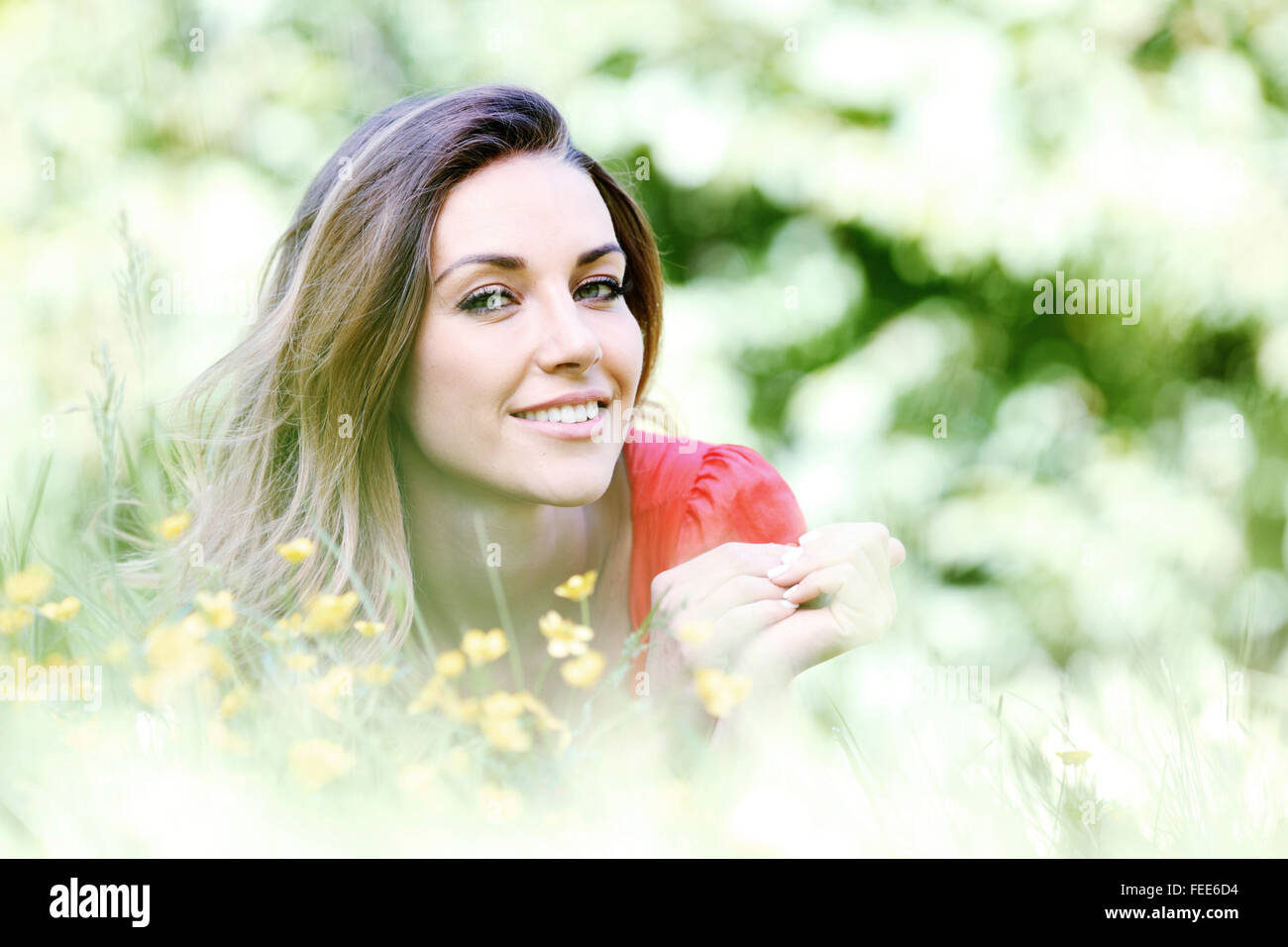 beautiful young woman in red dress lying on grass Stock Photo - Alamy