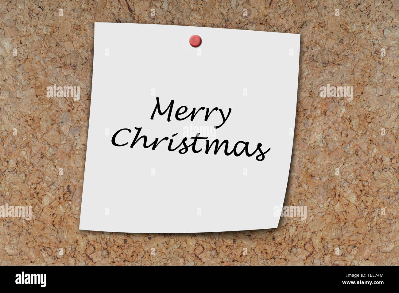 Merry christmas written on a memo pinned on a cork board Stock Photo