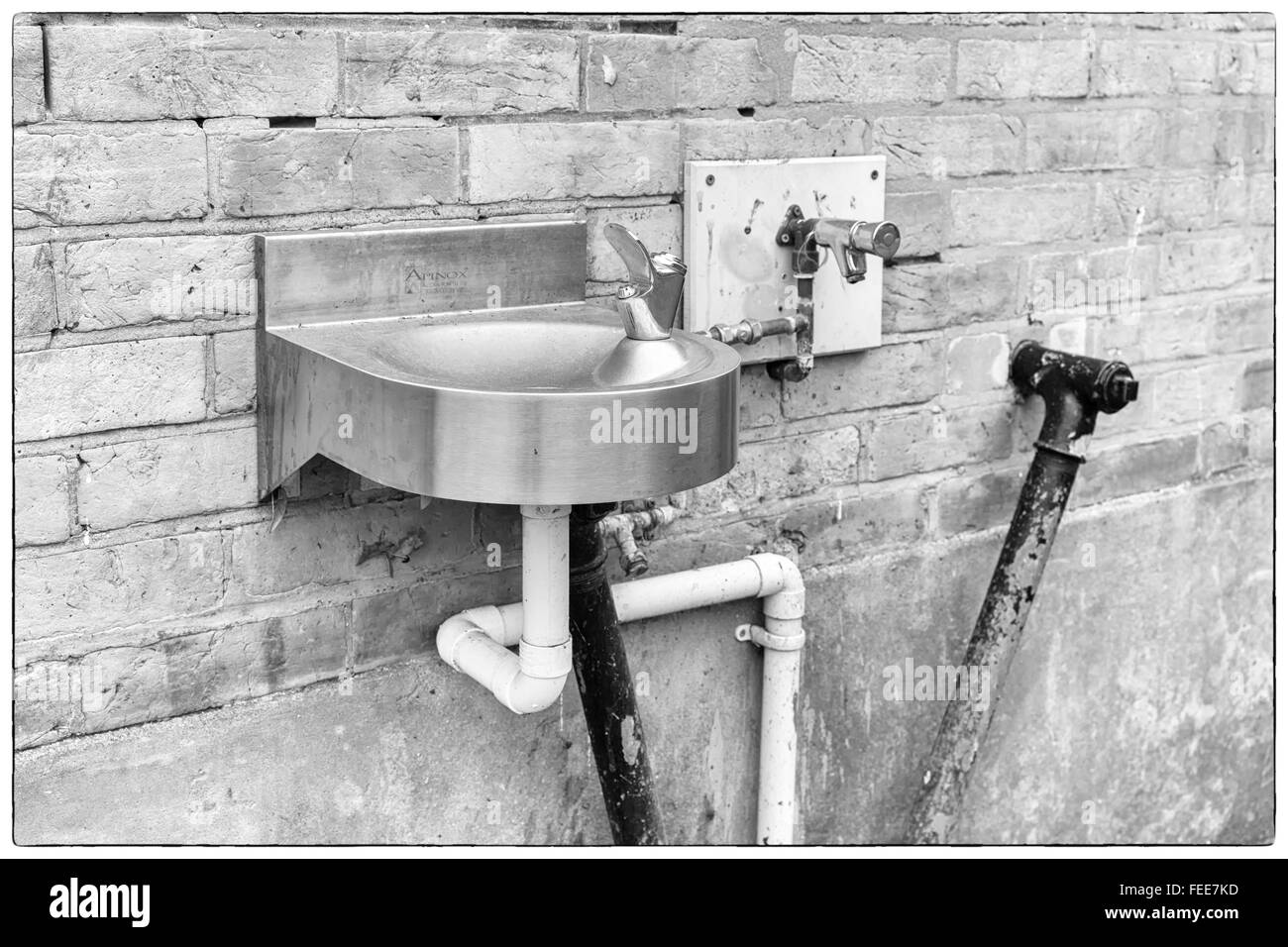 A photo of black and white angular water pipes connected to a stainless