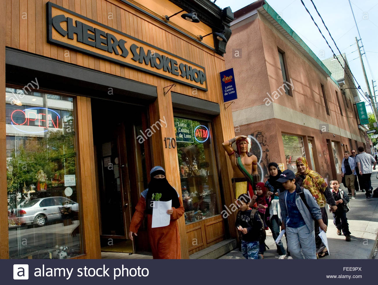Indian Smoke Shop >> Family Group Of Children And Women In Hijab And Niqab Pass By Cigar Indian Smoke Shop >> Family Group Of Children And Women In Hijab And Niqab Pass By Cigar