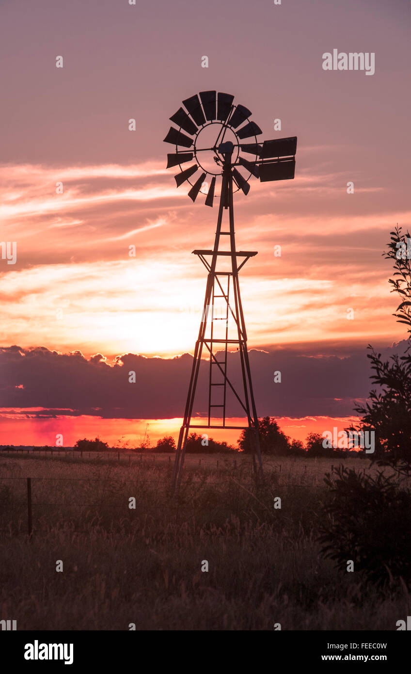 Windmill at sunset on country bush outback farm Queensland Australia Stock Photo
