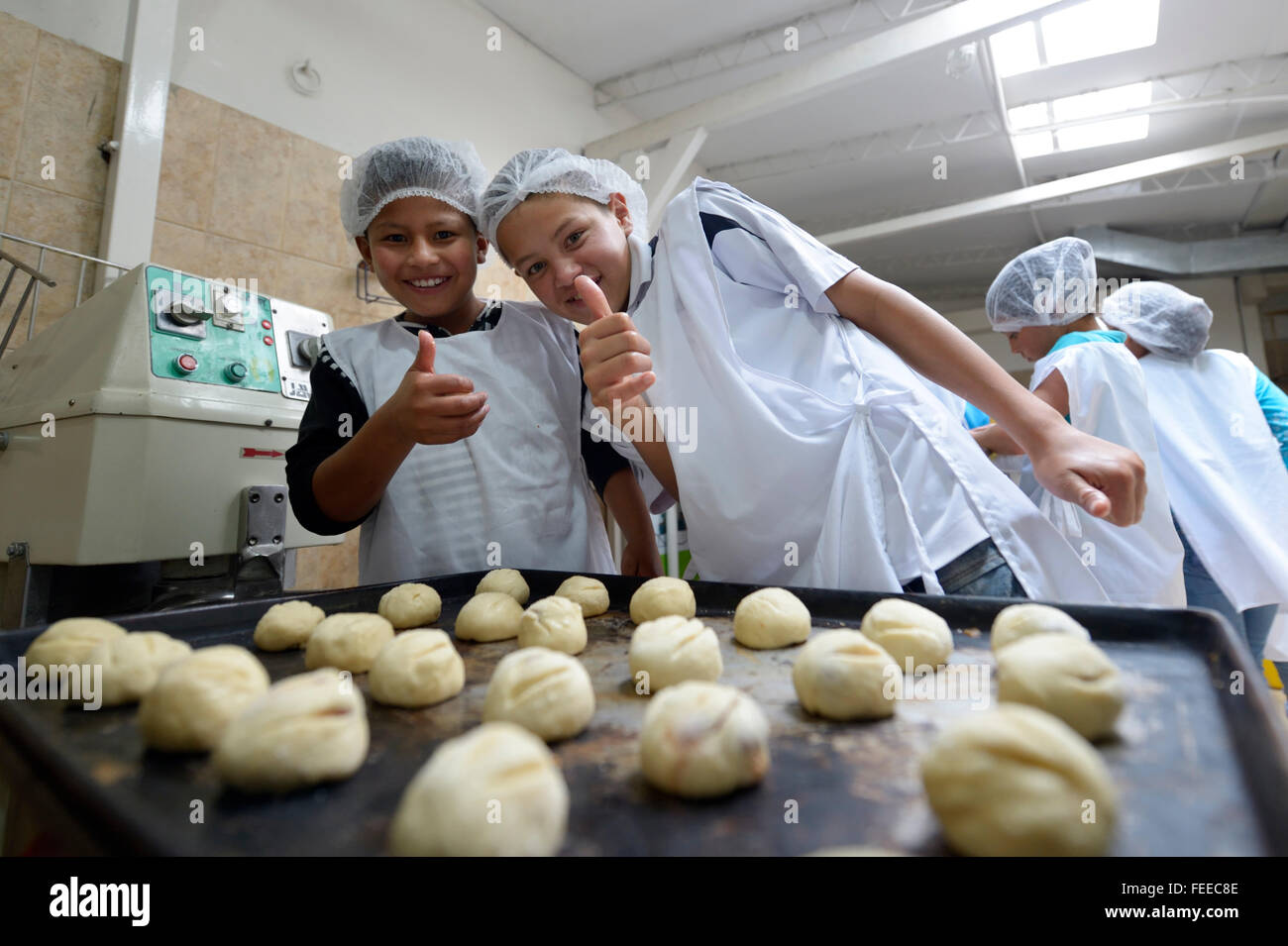 Two boys behind baking tray with raw dough, bakery, vocational training