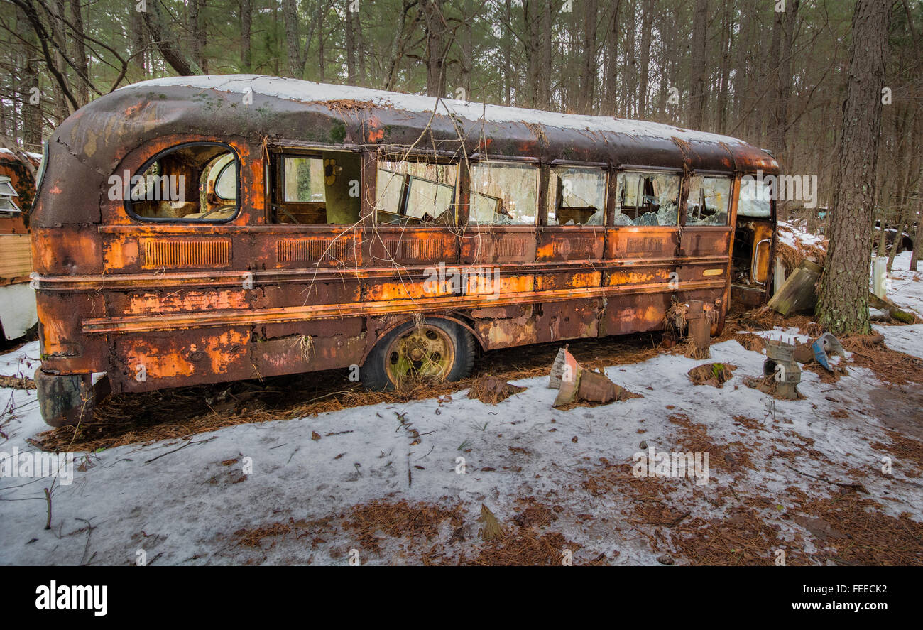 Rusty old school bus sitting in junkyard Stock Photo