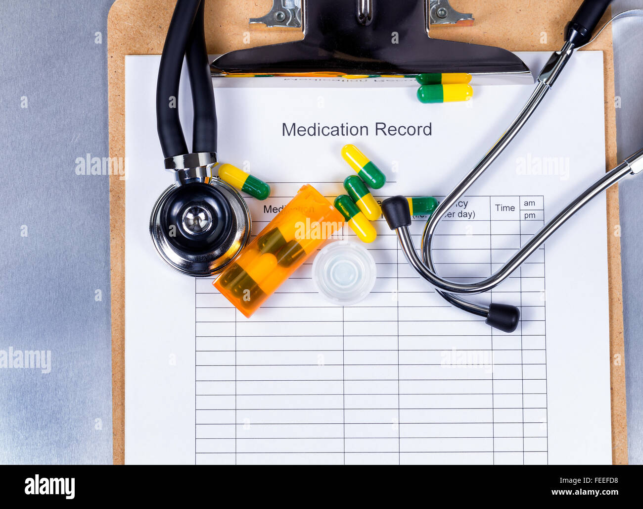 Patient medication record form with stethoscope, pills, container