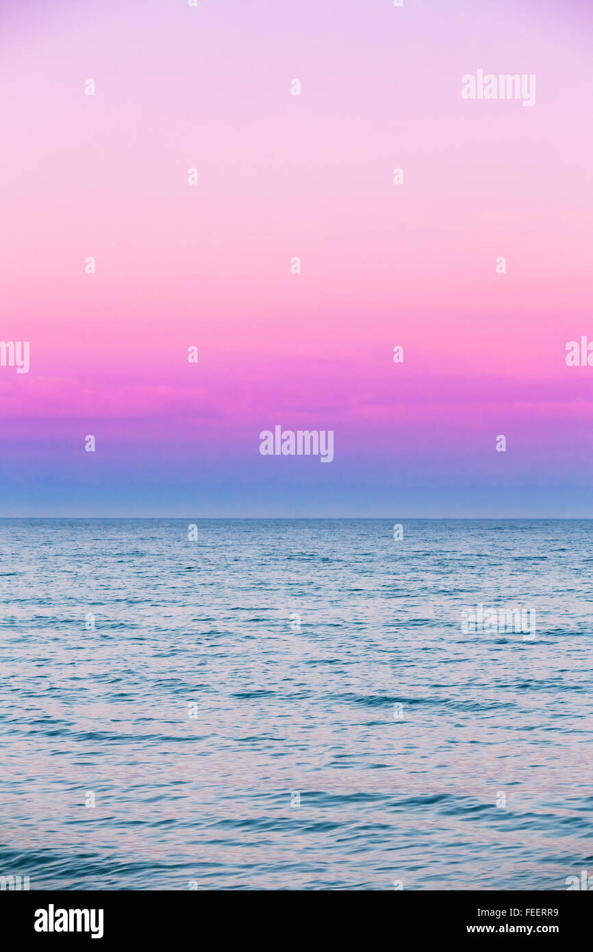Calm Sea and ocean beautiful pink red sky sunset Sunrise on the horizon, background. Stock Photo