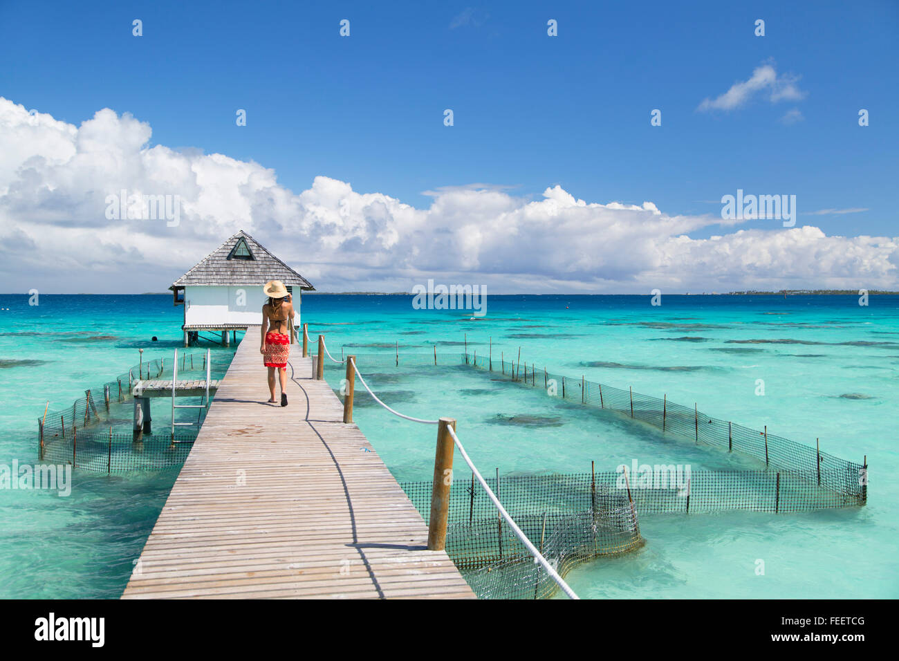 Woman walking on jetty, Fakarava, Tuamotu Islands, French Polynesia