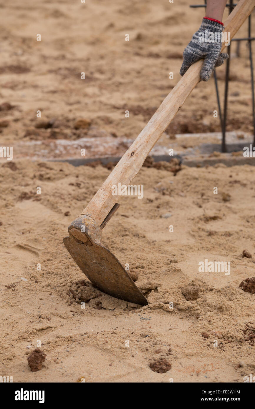 Digging the soil with a hoe at construction Stock Photo Alamy