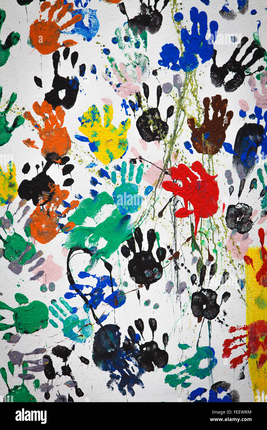 Graffiti colorful hand print on dirty white wall Stock Photo