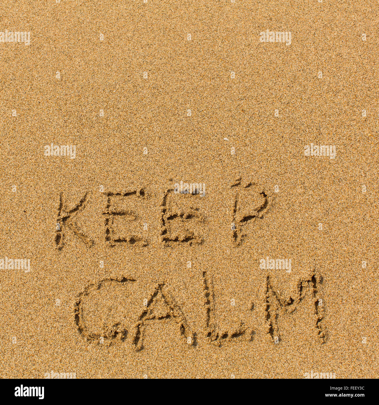 Keep calm - text written on sandy beach. Background, texture of the sand. Stock Photo