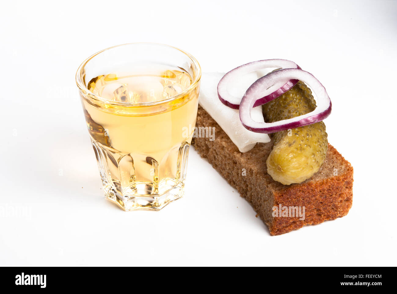 Russian vodka in small glass with black bread, pickled, onion and bit of lard on white background Stock Photo