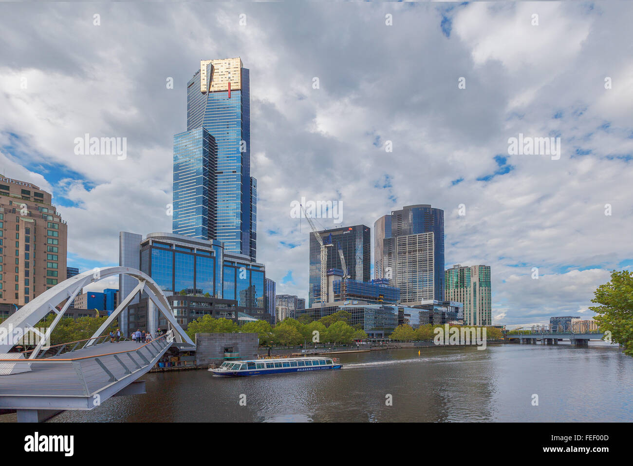 MELBOURNE - JAN 31 2016: View of Yarra river, Eureka Tower, Southbank footbridge, and Melbourne river cruises boat. Stock Photo
