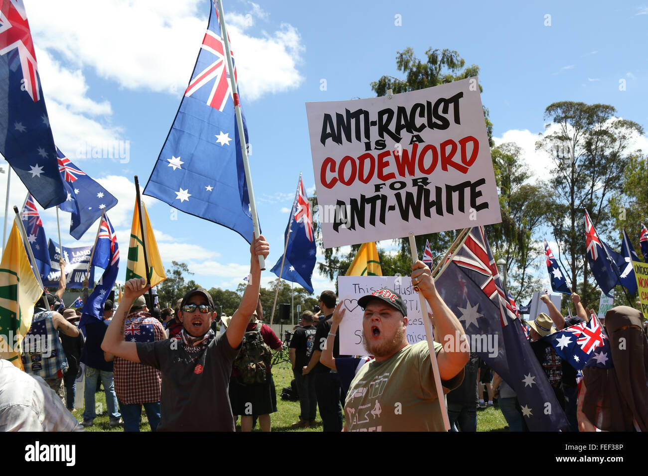 Canberra, Australia. 6 February 2016. Pictured: A protester holds a sign saying, ‘Anti Racist is a Codeword for Anti-white’ outside Parliament House in Canberra as they exchange words with counter protesters. A rally was held in the nation’s capital Canberra as part of the international day of protests by the PEGIDA movement, which is against the Islamification of the western world. Credit:  Richard Milnes/Alamy Live News Stock Photo