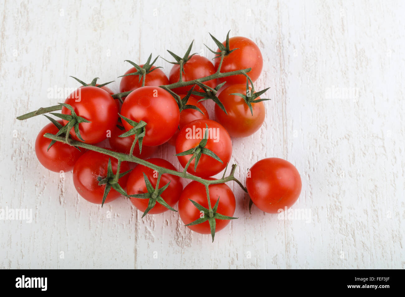 Cherry tomatoes on the branch wood background Stock Photo - Alamy