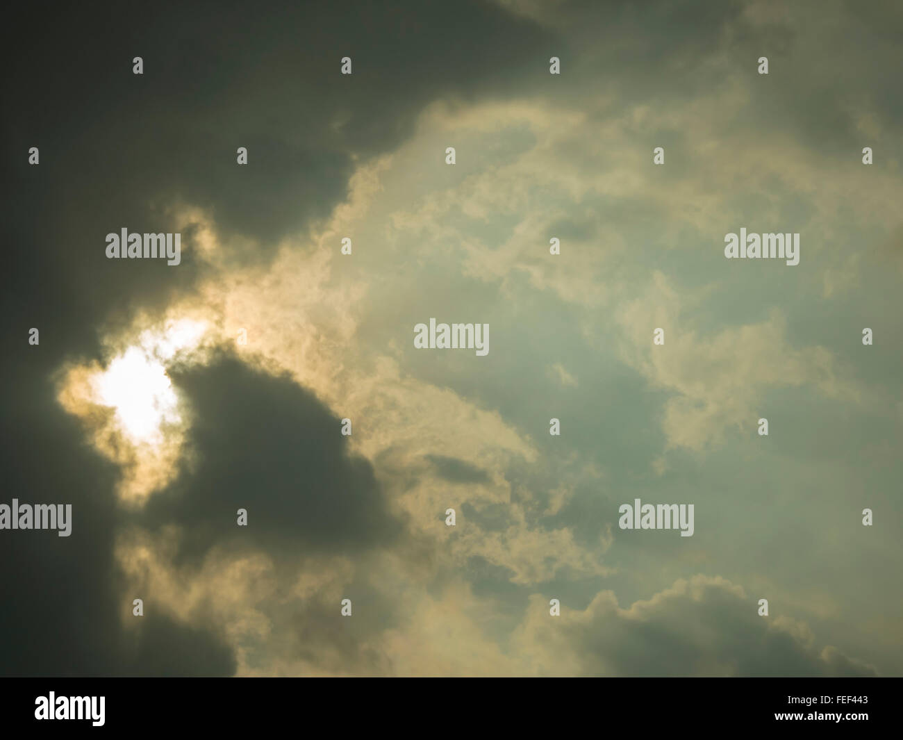 Yellowish light bleeding through clouds Stock Photo Alamy