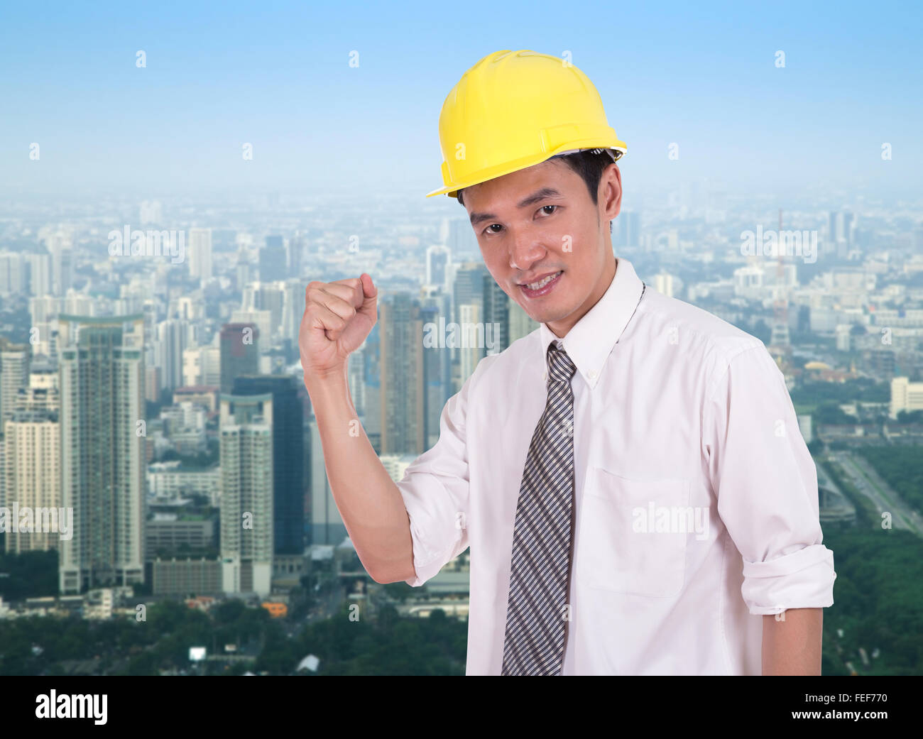 Happy engineer celebrating with arm raised, concept of successful, city ...