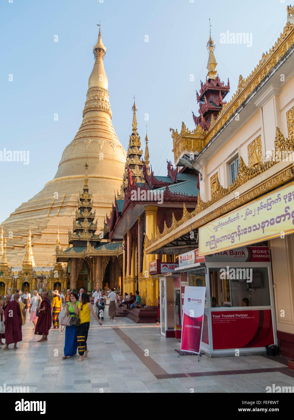 Money exchange booth on the pagoda premises and the main stupa of Shwedagon Zedi Daw Pagoda, Yangon, Myanmar. Stock Photo