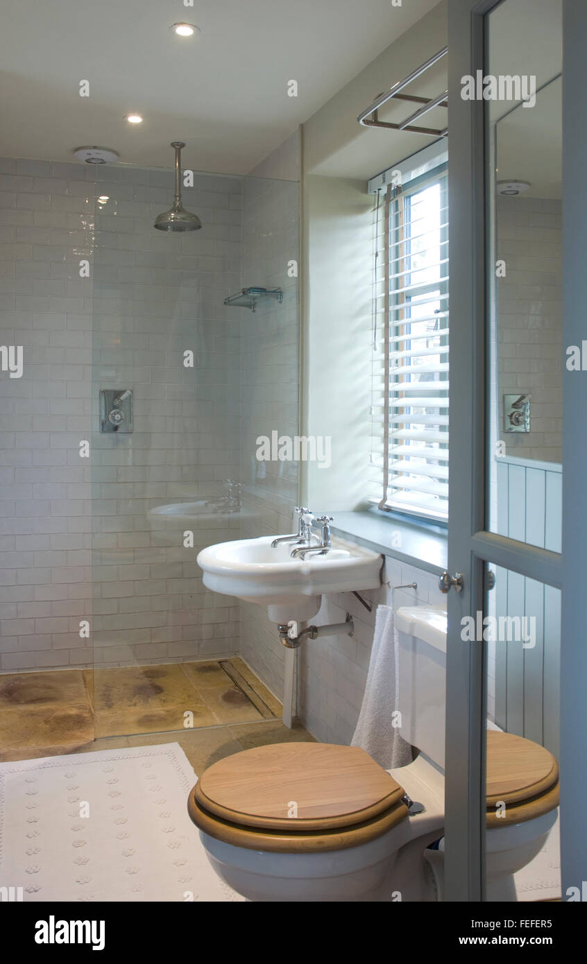 shower room with toilet,and basin. contemporary, open door with blinds. Stock Photo