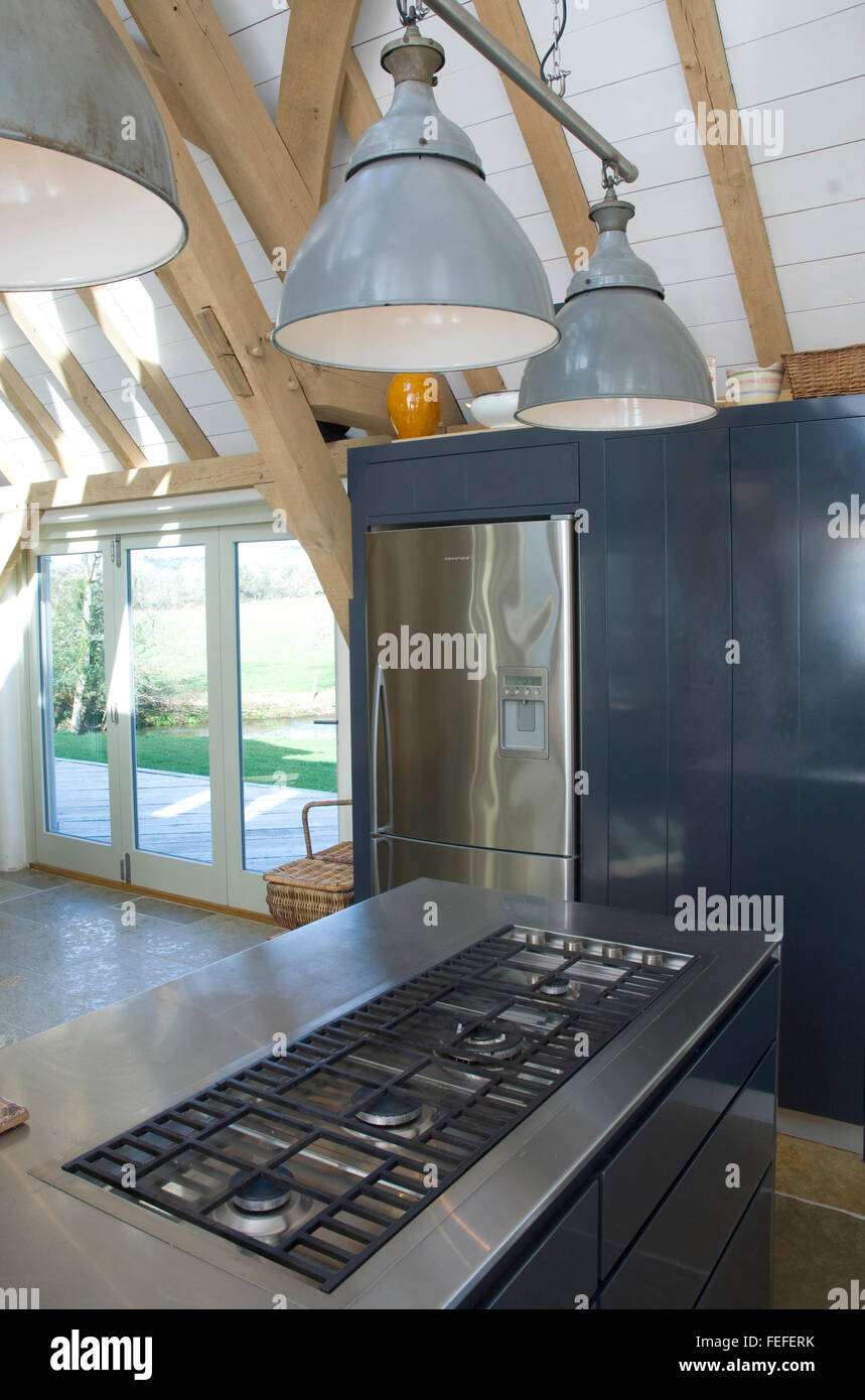 contemporary kitchen detail, cooker, gas cooker, overhead lighting, barn conversion, island unit, glazed doors. Stock Photo