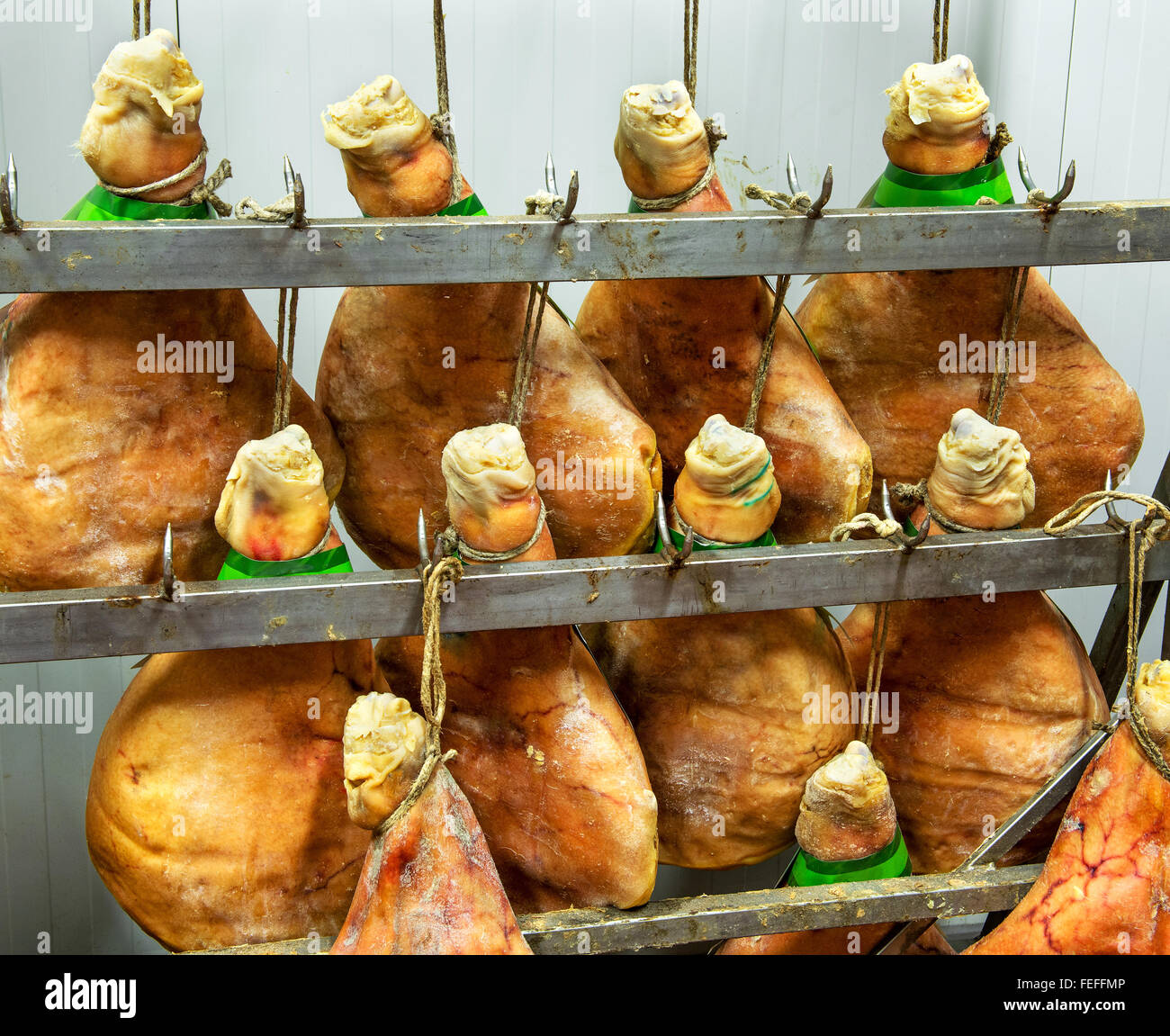 Italian Parma or prosciutto hams hanging on meat hooks Stock Photo