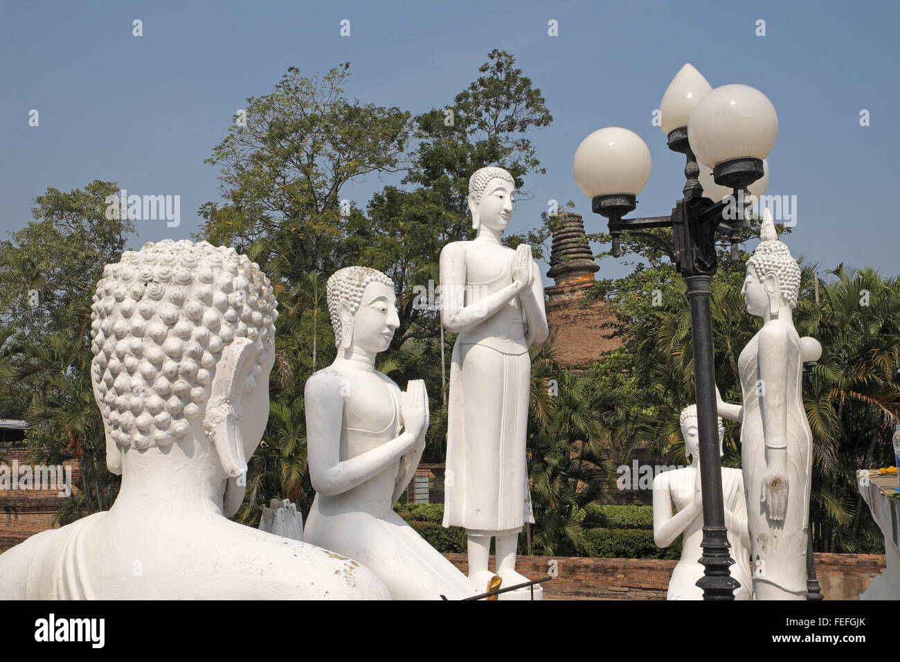 Buddha statues beneath the huge chedi of Wat Yai Chai Mongkol, Ayutthaya, Thailand, Asia. Stock Photo