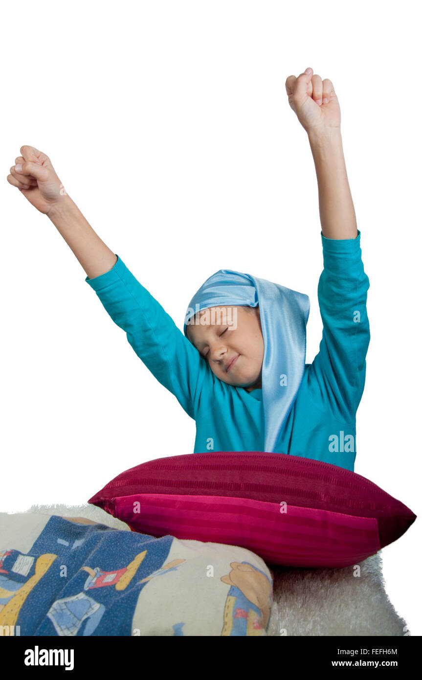 Cute boy near maroon pillow stretching his self isolated on white Stock