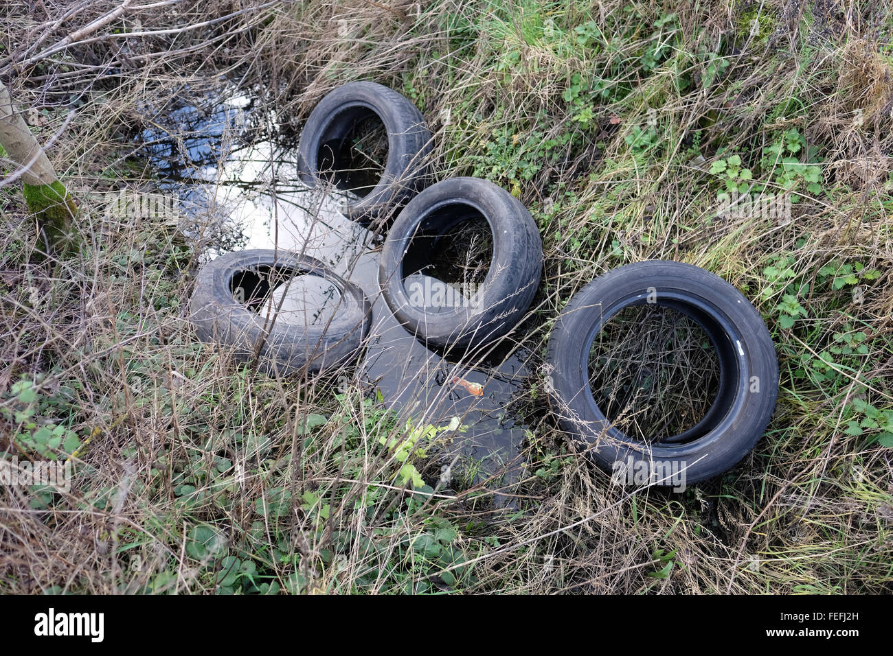 tyres dumped in a ditch Stock Photo