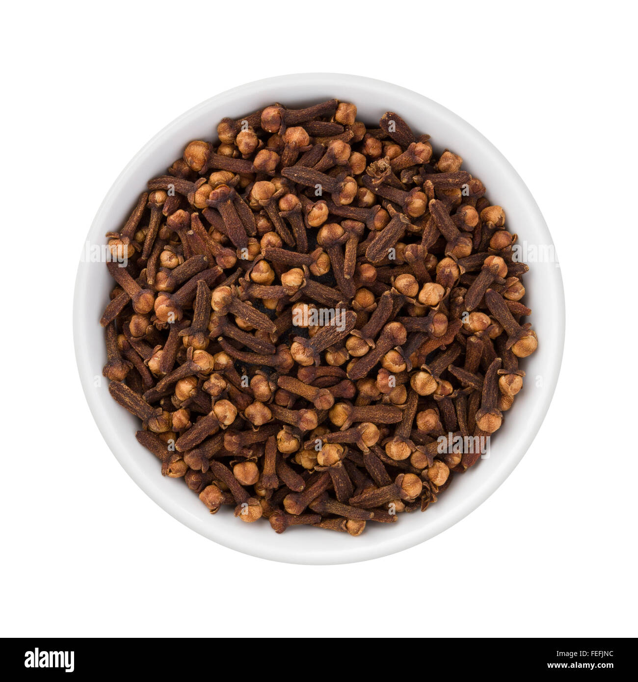 Cloves in a Ceramic Bowl. The image is a cut out, isolated on a white background. Stock Photo