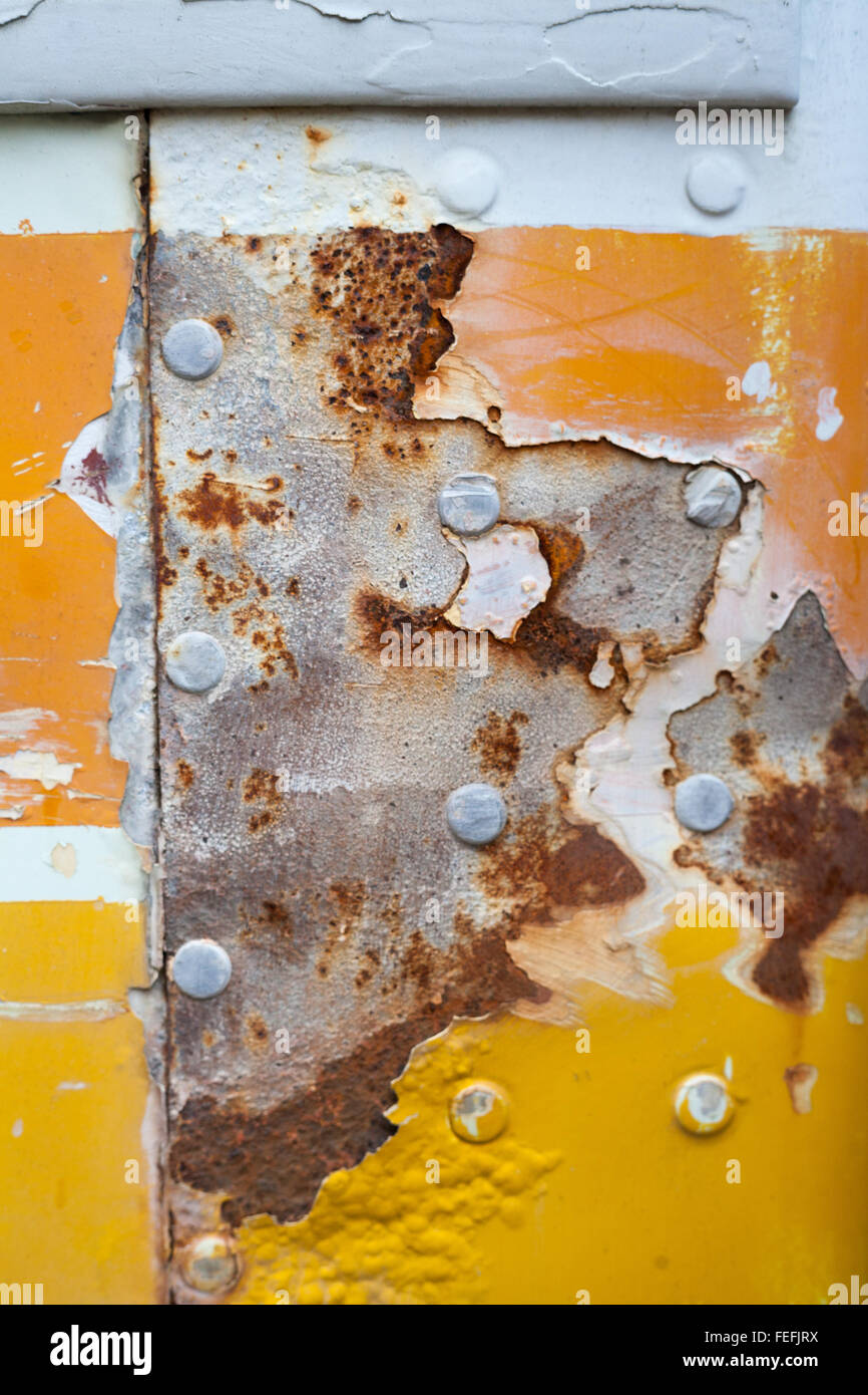 Orange and yellow paint worn, old and rusty and scratched metal textured through time. Stock Photo