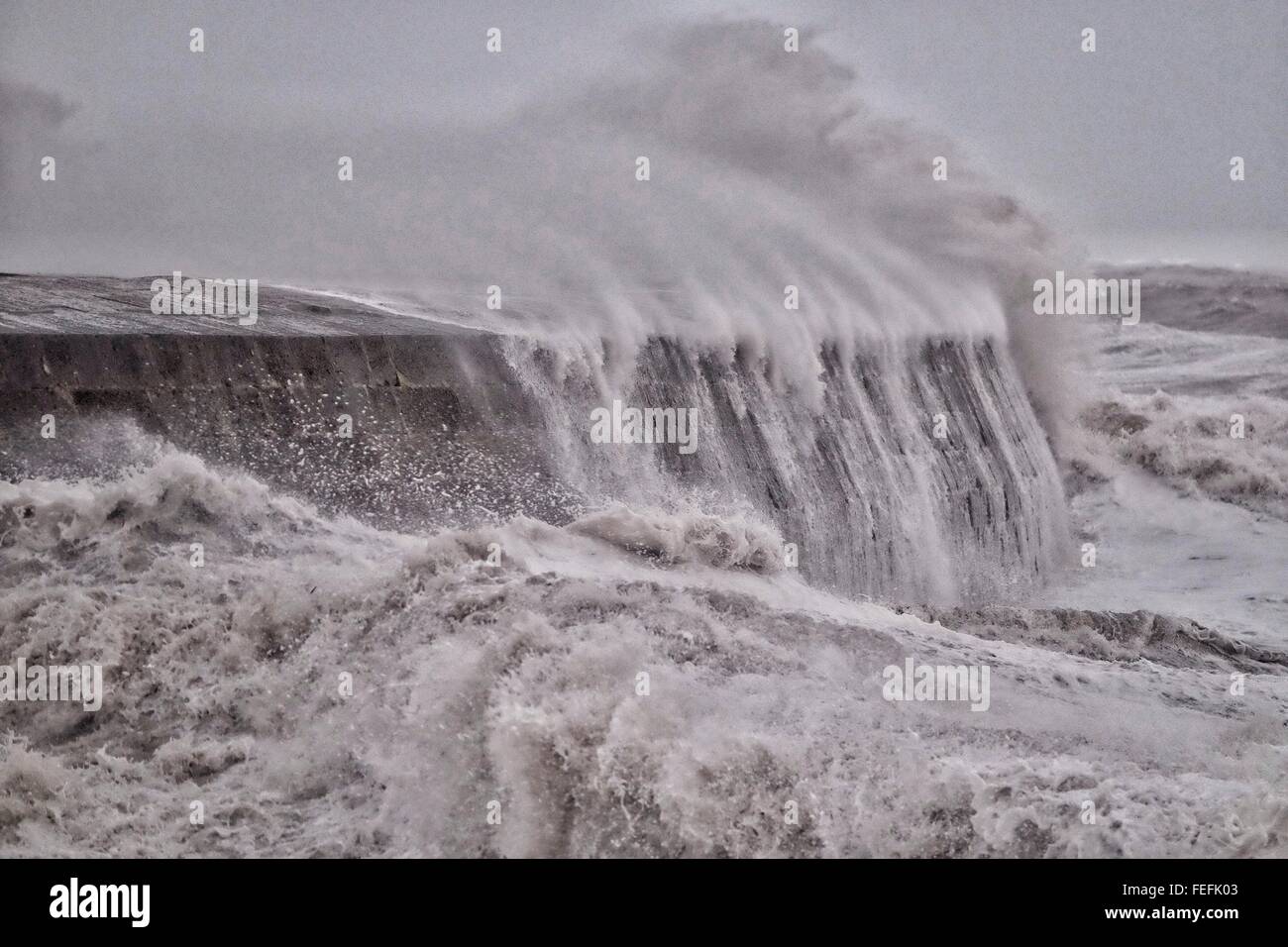 Lyme Regis, Dorset, UK. 6 February 2016. Waves crash over Lyme Regis historic Cobb at high tide as the Environment issue 35 Flood warnings and 48 Flood Alerts for the South West. Credit:  Tom Corban/Alamy Live News Stock Photo