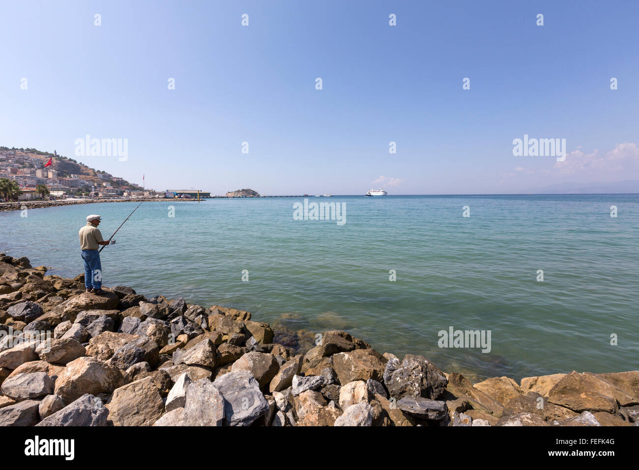 Man fishing in the Aegean sea in the Promenade in Atatürk Boulevard looking the in Kuşadası,  Turkey Stock Photo