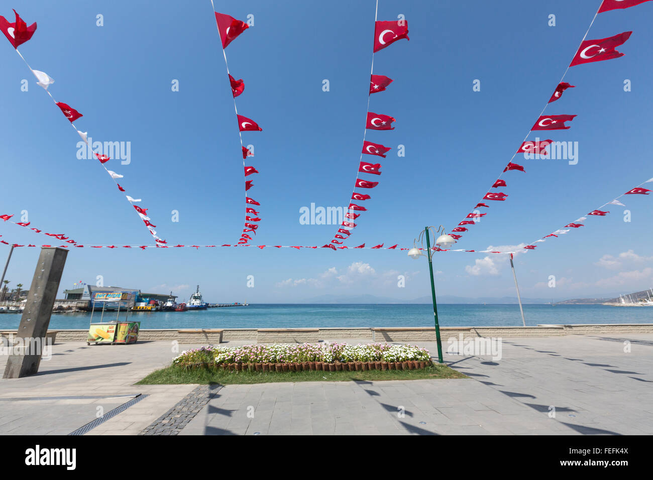 Small Turkish flags with Aegean sea in Atatürk Boulevard in Kuşadası harbor, Turkey Stock Photo
