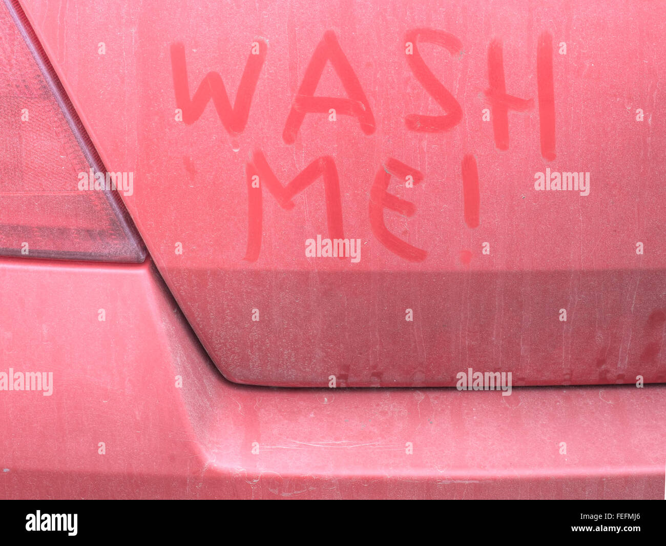 Dirty red car wash me written in grime Stock Photo Alamy