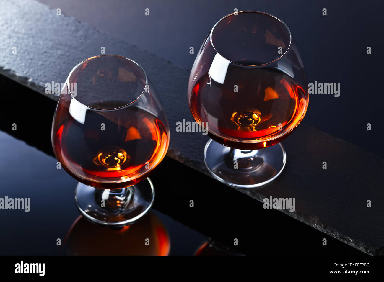 Snifter with brandy on a black background Stock Photo Alamy