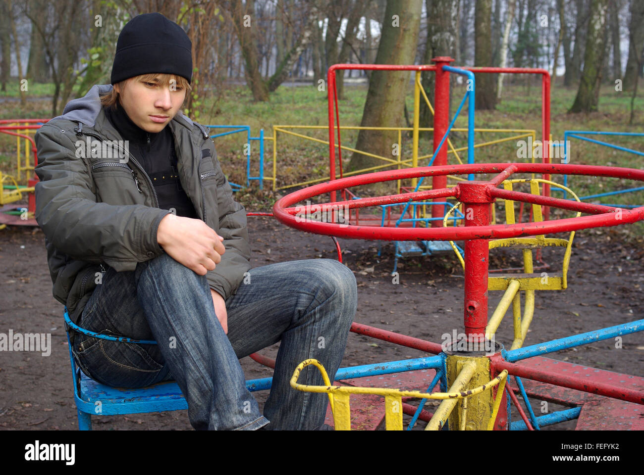 Sad teenager at a old abandoned playground Stock Photo