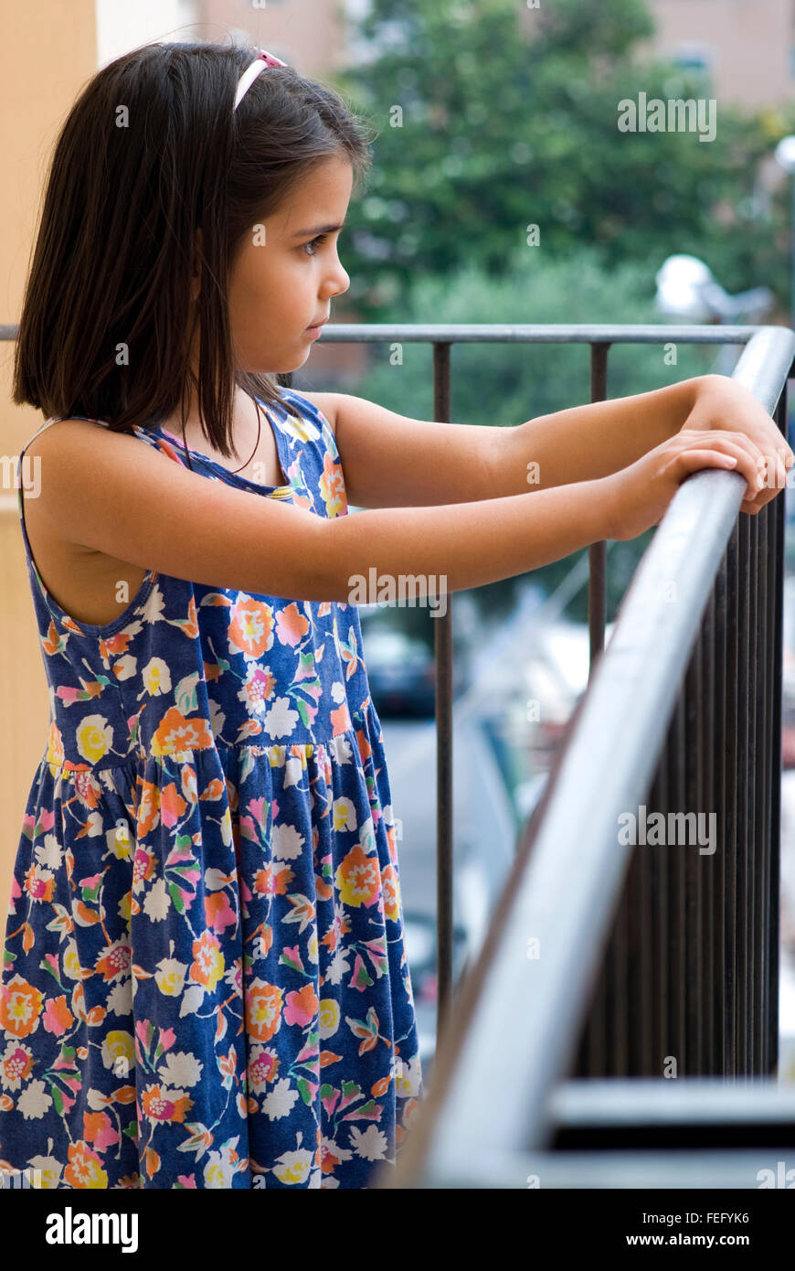 Pretty girl at her balcony looking away Stock Photo