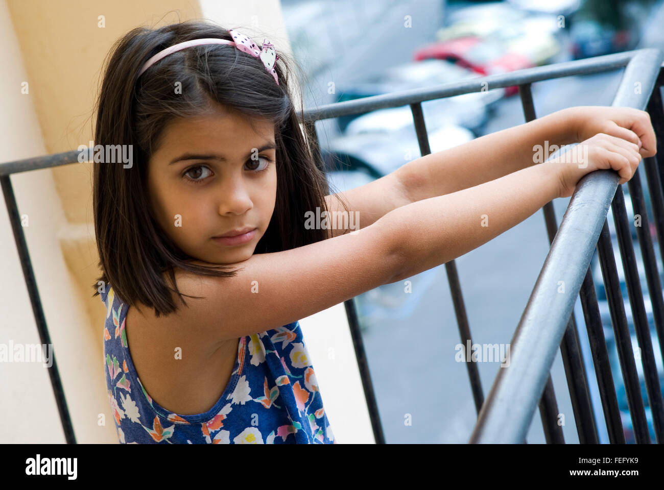 Girl standing by a railing of the balcony Stock Photo