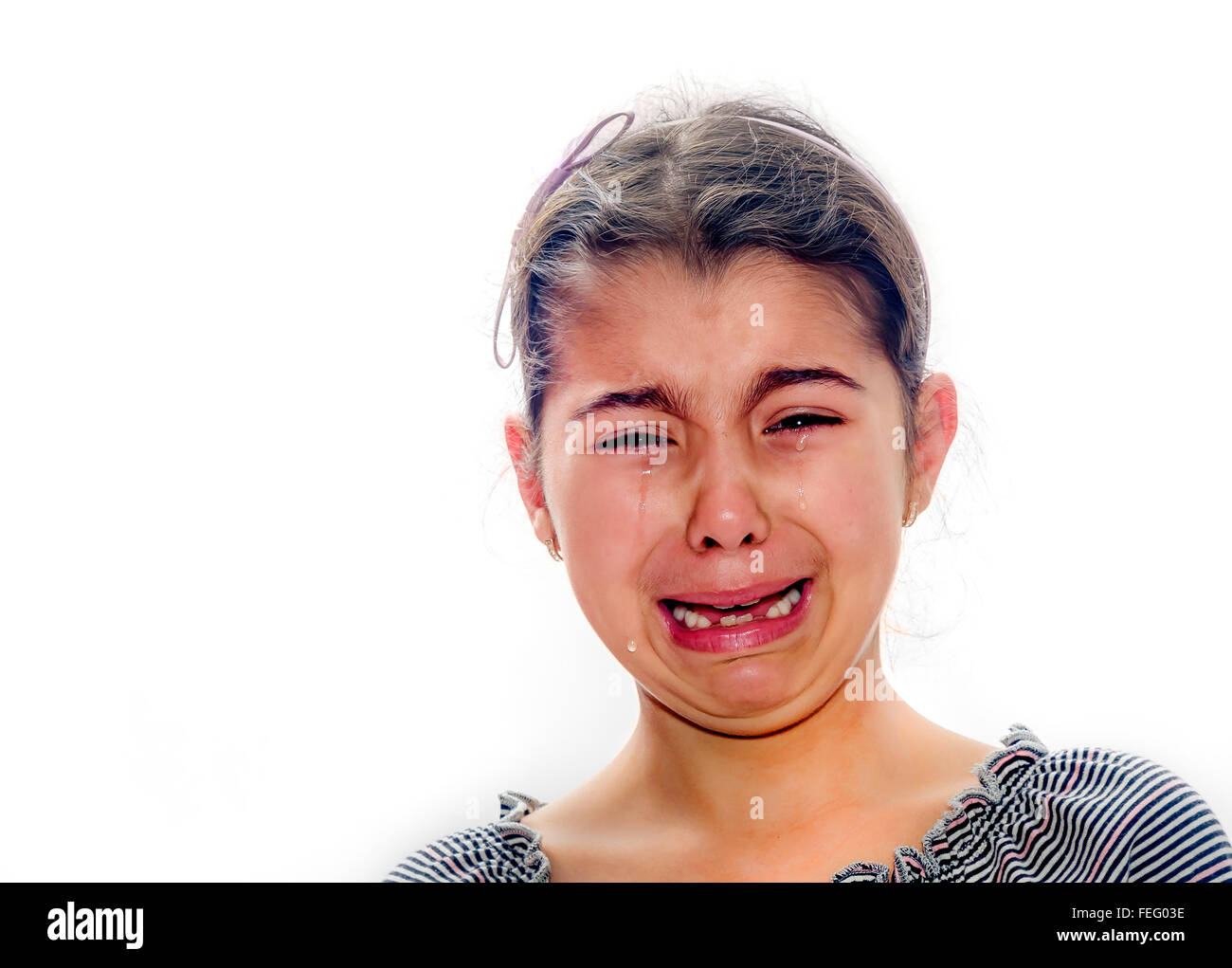Little girl crying with tears rolling down her cheeks isolated on white Stock Photo