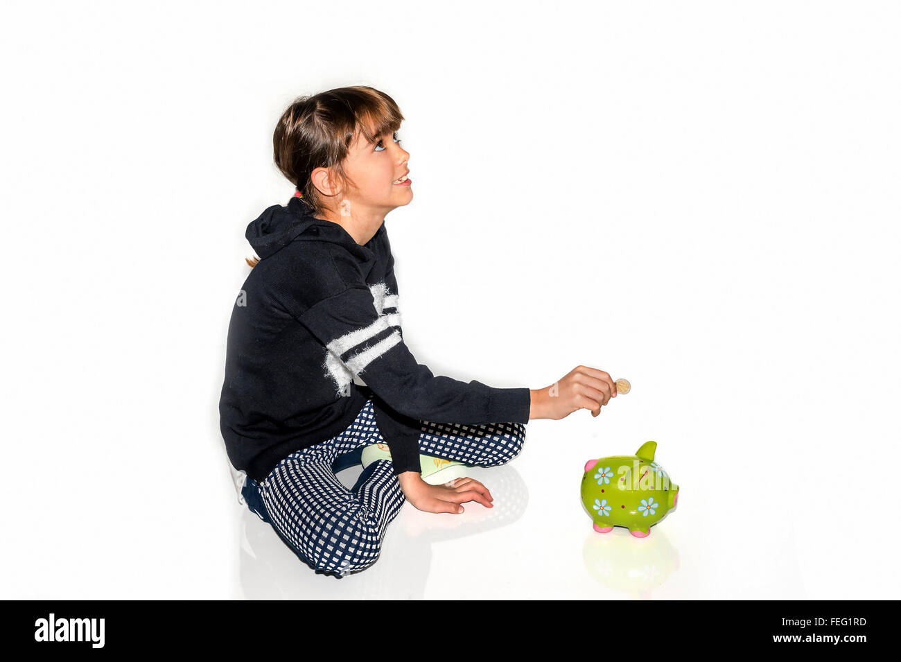 Little girl saving money in piggy bank Stock Photo - Alamy