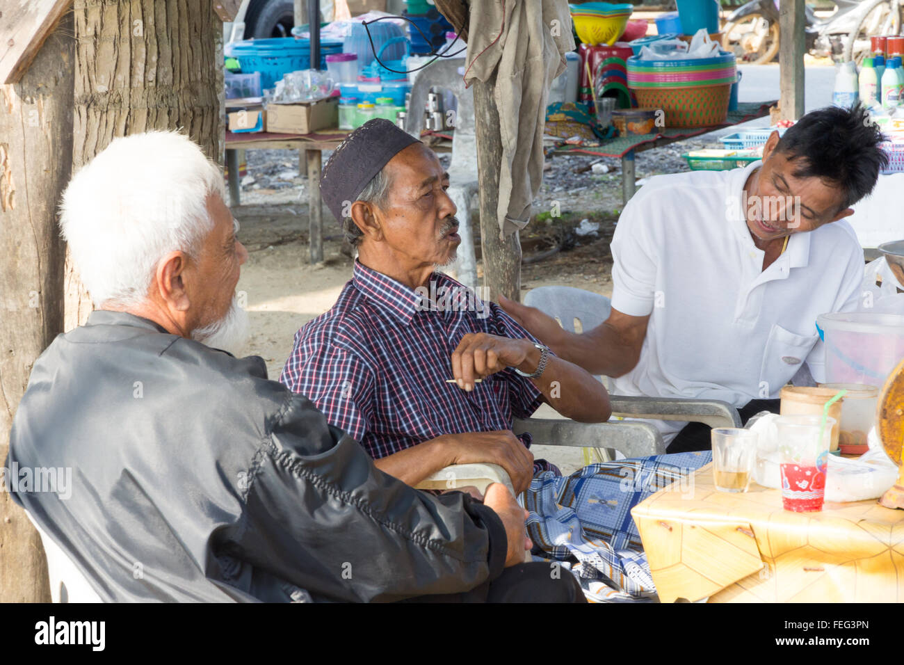 Sichon, Thailand-February 12th 2015: Muslim men talking. Older men often gather together to chat and drink tea or coffee. Stock Photo