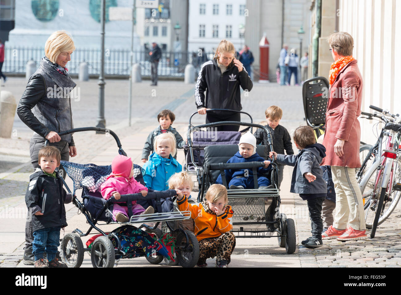 Childminders with group of children, Royal Palace Square, Copenhagen (Kobenhavn), Kingdom of Denmark Stock Photo