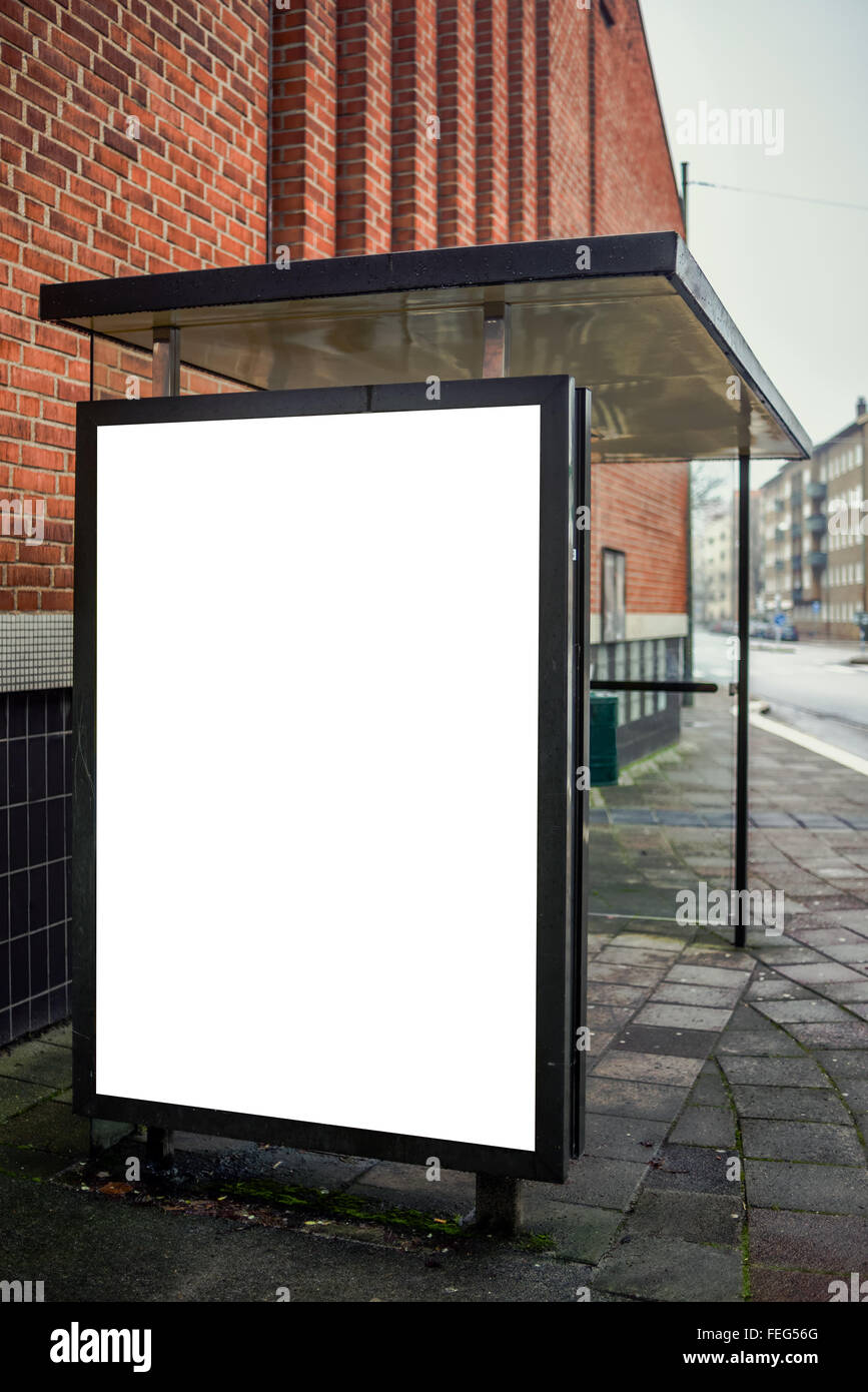 Blank bus stop advertising billboard on empty street as copy space for outdoor poster ad mock up. Stock Photo