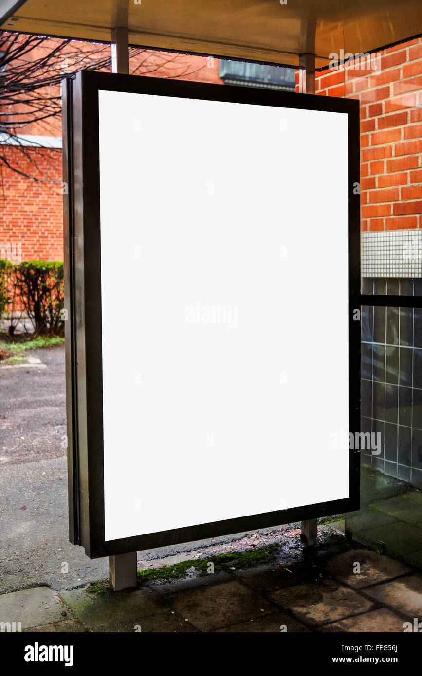 Blank bus stop advertising billboard on empty street as copy space for outdoor poster ad mock up. Stock Photo