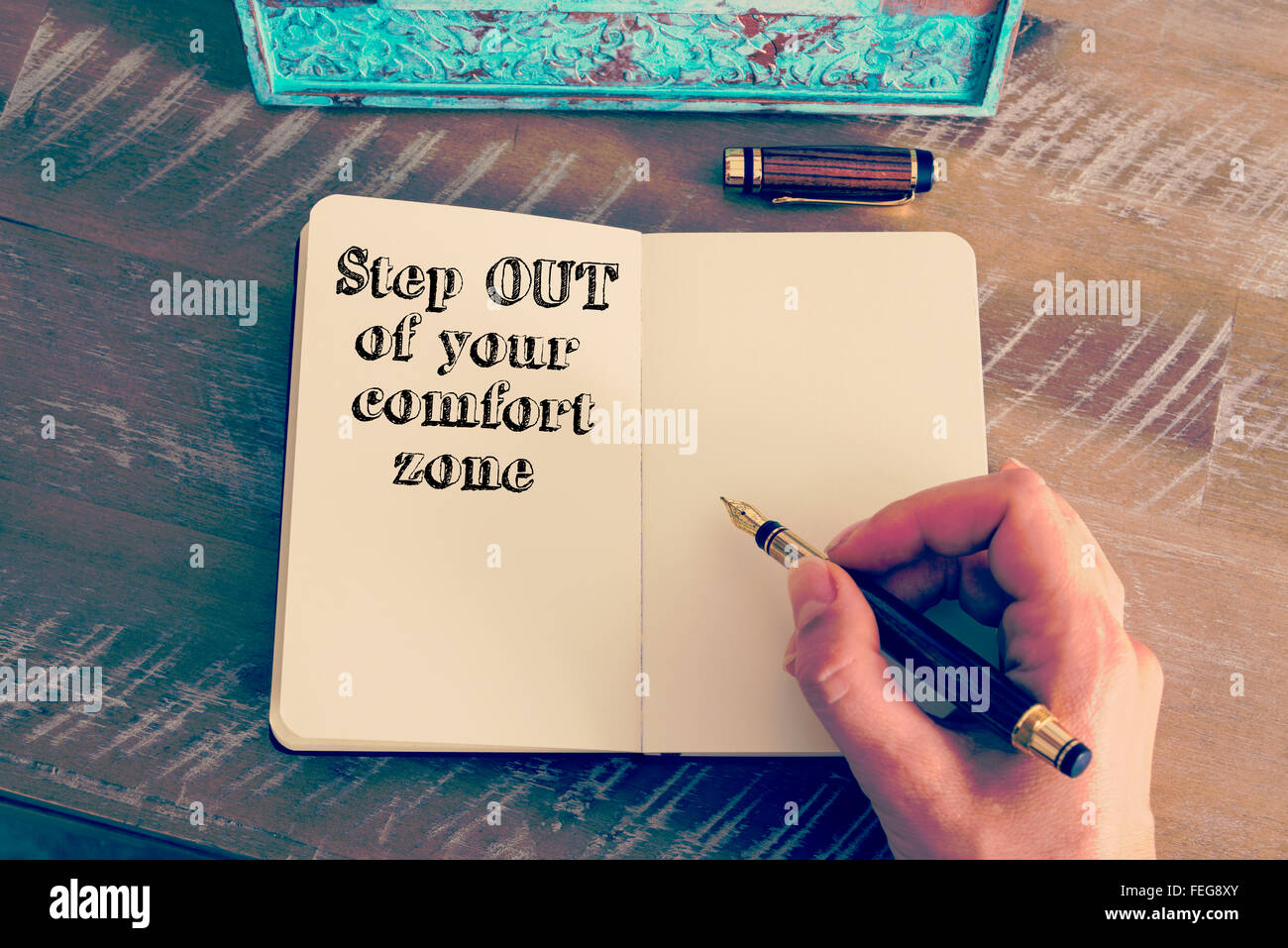 Retro effect and toned image of a woman hand writing a note with a fountain pen on a notebook. Stock Photo