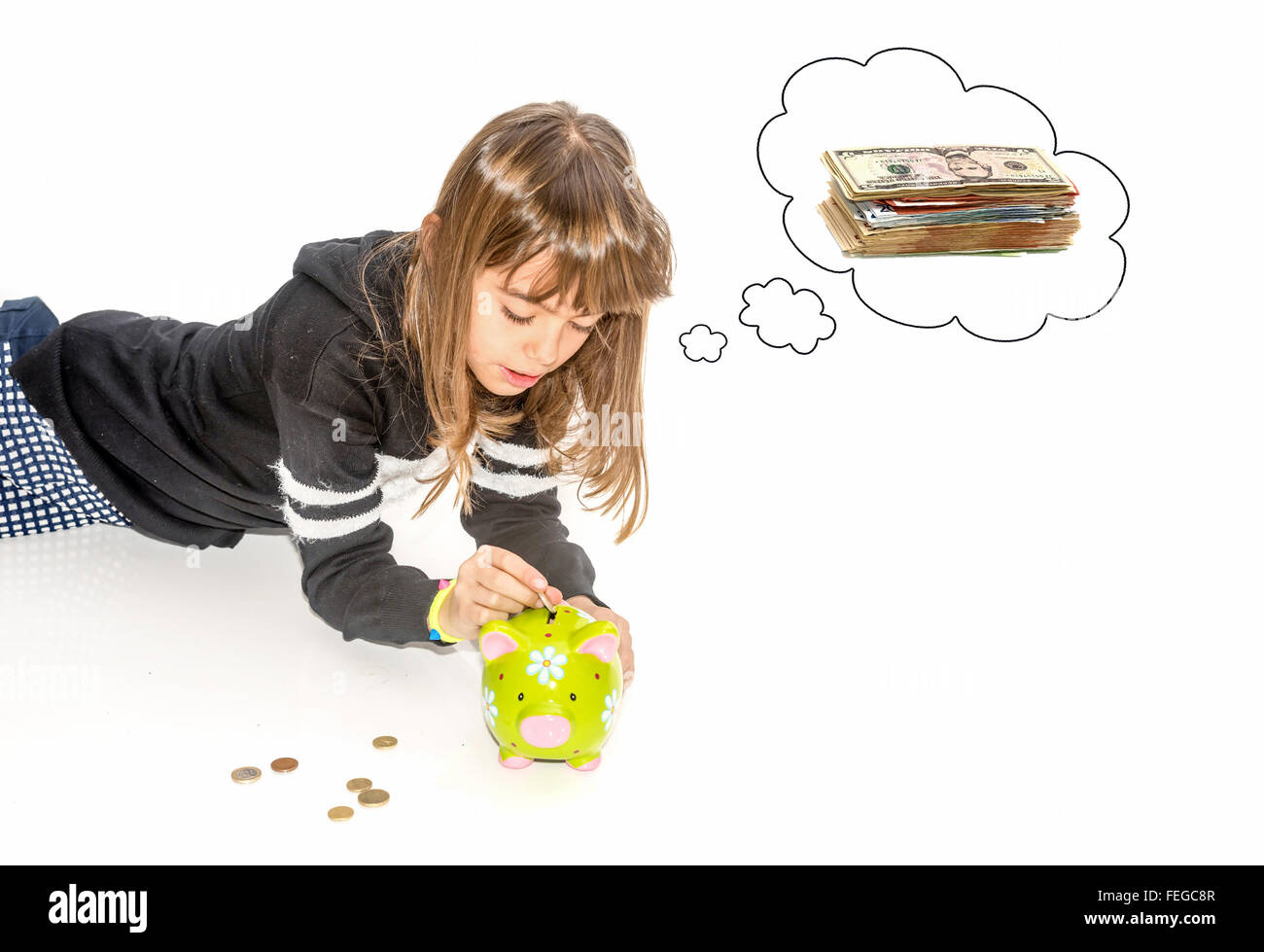 Little girl saving money in piggy bank Stock Photo - Alamy